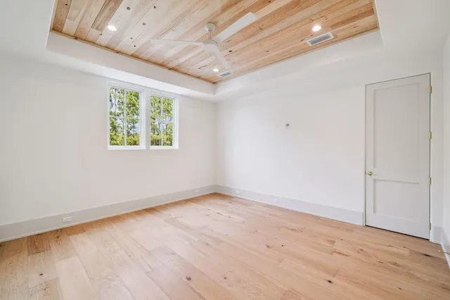 an empty room with wooden floor and window