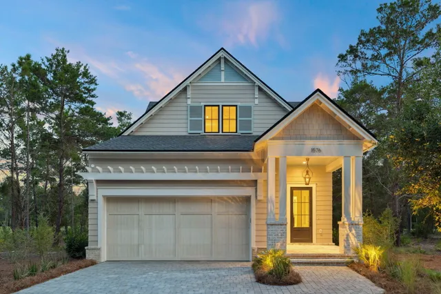 a view of a house with large windows and a small yard