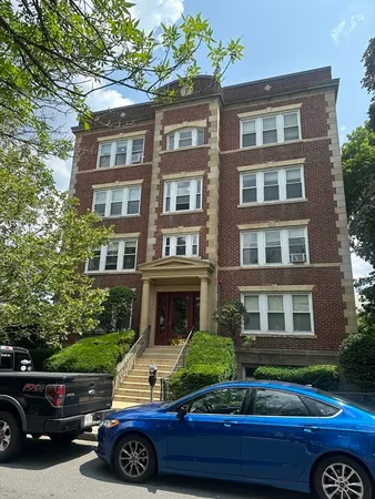 a car parked in front of a brick house