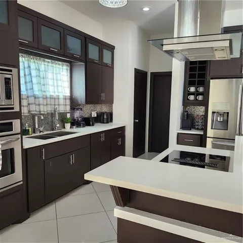 a kitchen with kitchen island a counter top space a sink and appliances