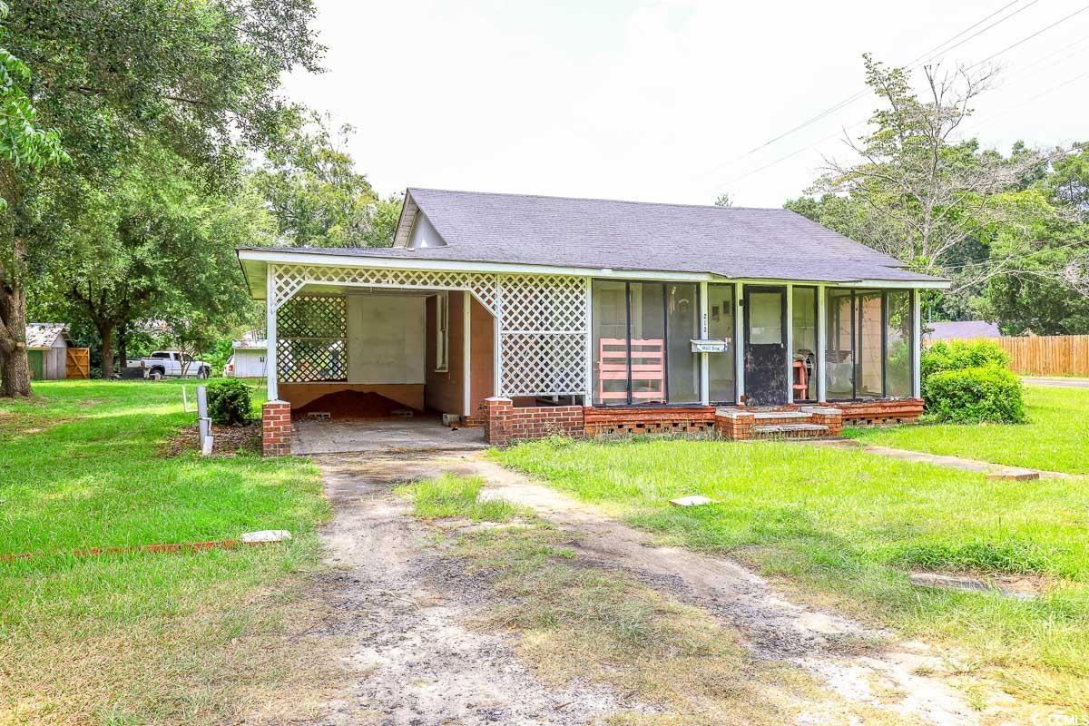 213 North Magnolia Avenue Andrews, SC 29510 - Photo 1 of 20 View of front of property with dirt driveway, a carport, and a shingled roof