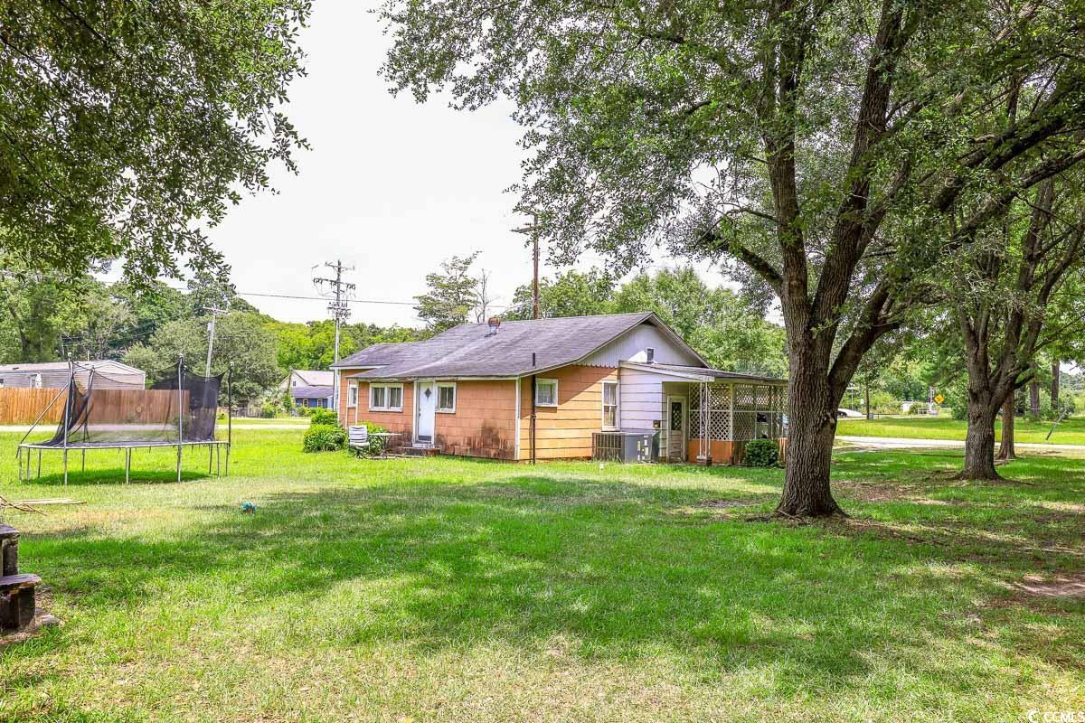 213 North Magnolia Avenue Andrews, SC 29510 - Photo 19 of 20 Back of house with a trampoline and a lawn