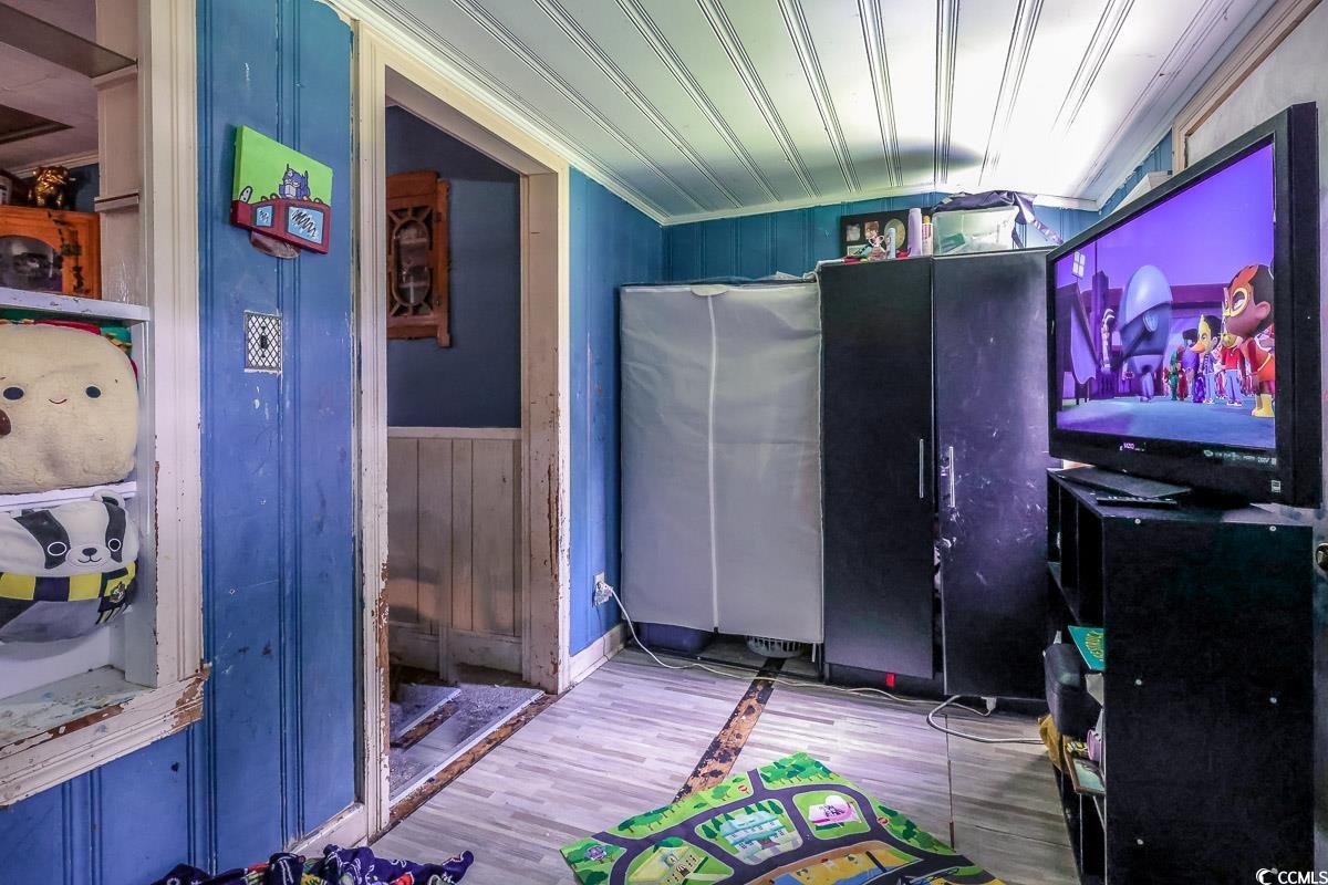 213 North Magnolia Avenue Andrews, SC 29510 - Photo 8 of 20 Miscellaneous room with wood walls, wood finished floors, and crown molding
