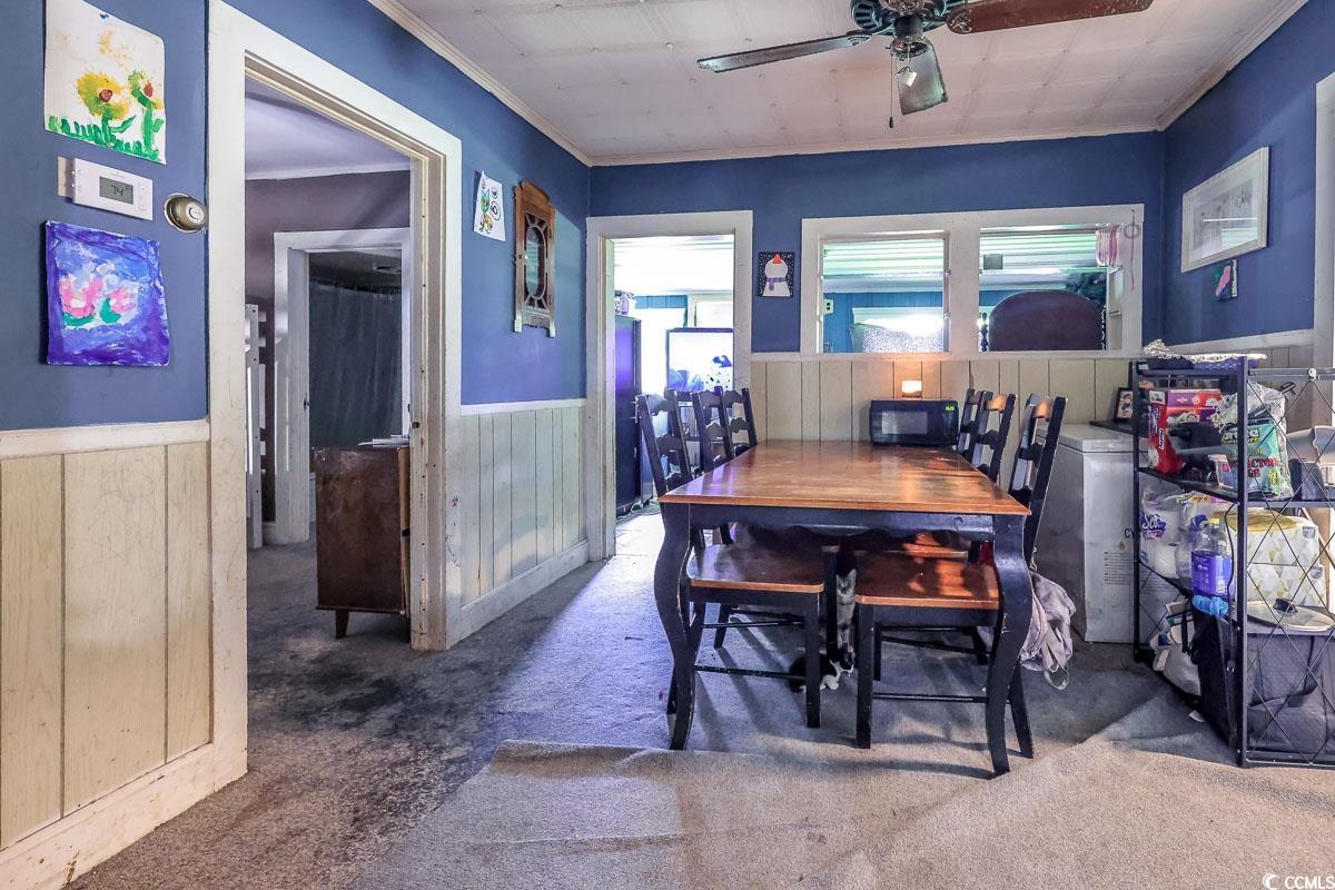 213 North Magnolia Avenue Andrews, SC 29510 - Photo 9 of 20 Carpeted dining area featuring crown molding, a wainscoted wall, and a ceiling fan