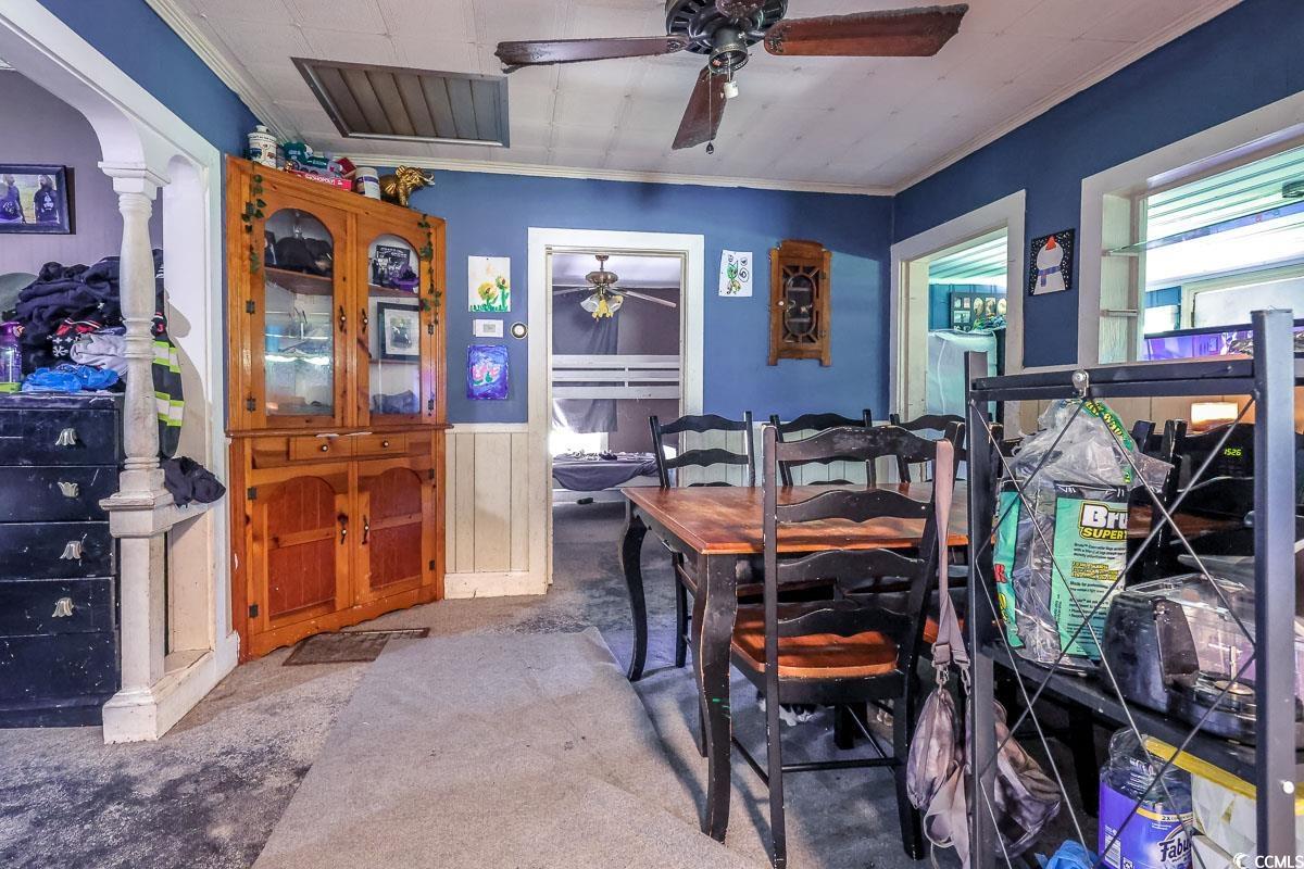 213 North Magnolia Avenue Andrews, SC 29510 - Photo 10 of 20 Carpeted dining space featuring ornamental molding, wainscoting, and a ceiling fan