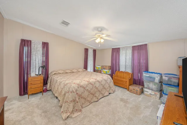 a spacious bedroom with a bed and a chandelier