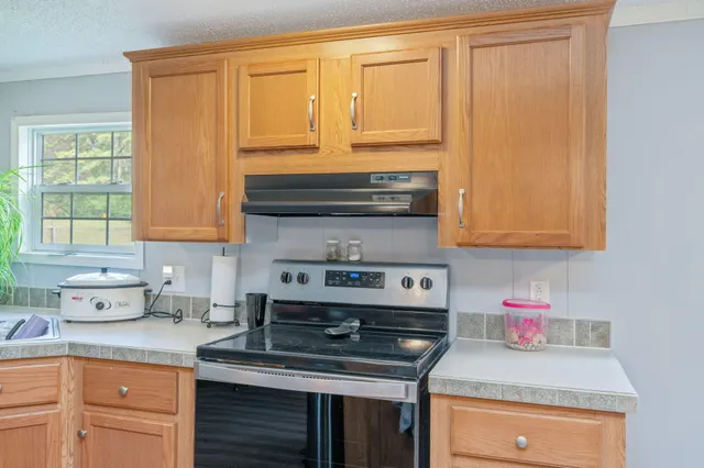 a kitchen with stainless steel appliances granite countertop a sink stove and cabinets