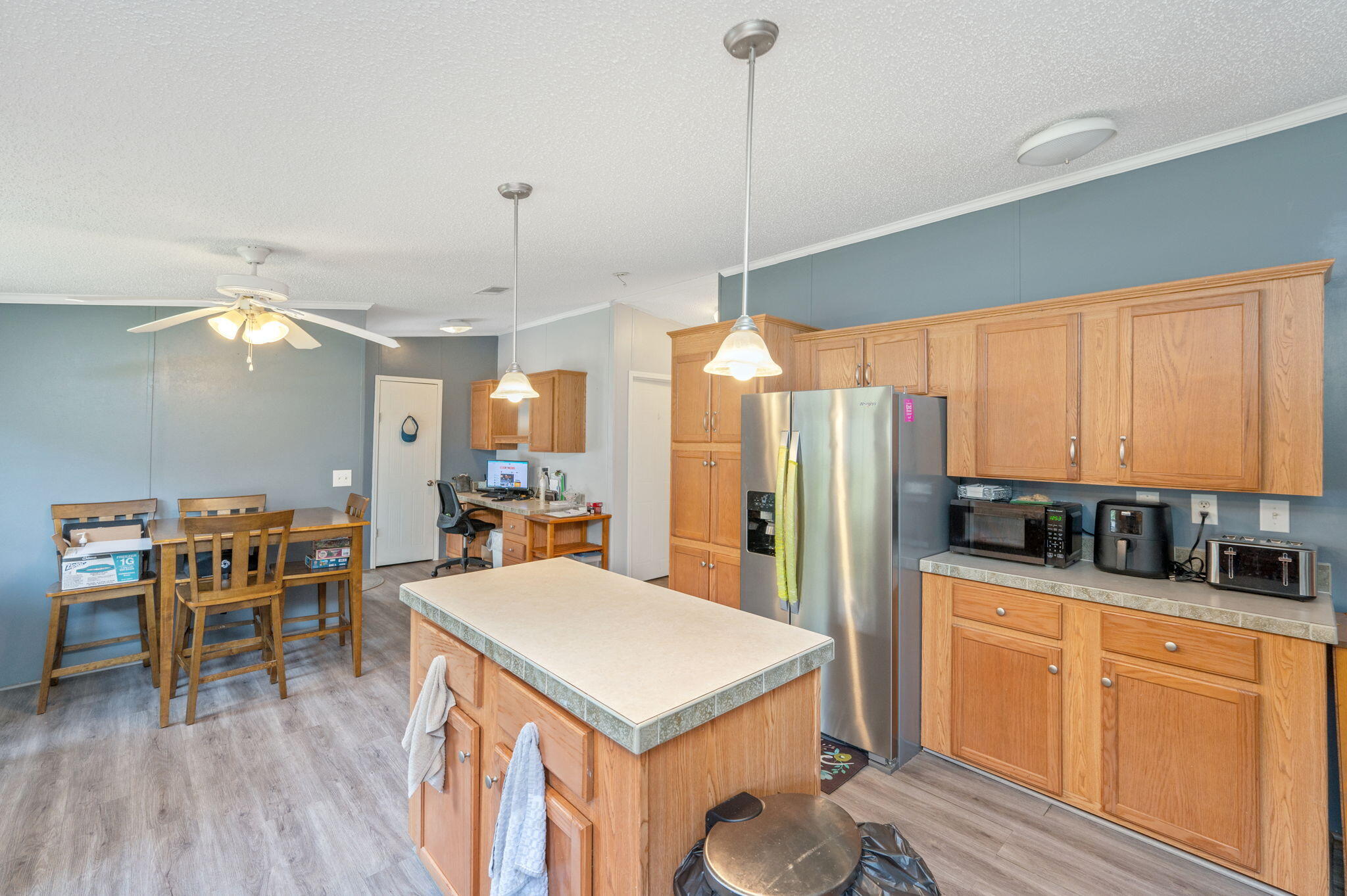 6918 Bill Lundy Road Laurel Hill, FL 32567 - Photo 9 of 27 a kitchen with stainless steel appliances granite countertop a stove a refrigerator a oven a sink with island chairs and wooden cabinets