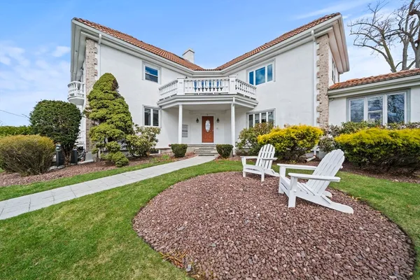 a view of a white house with a yard and plants