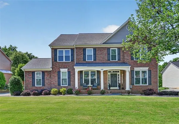 front view of a brick house with a yard