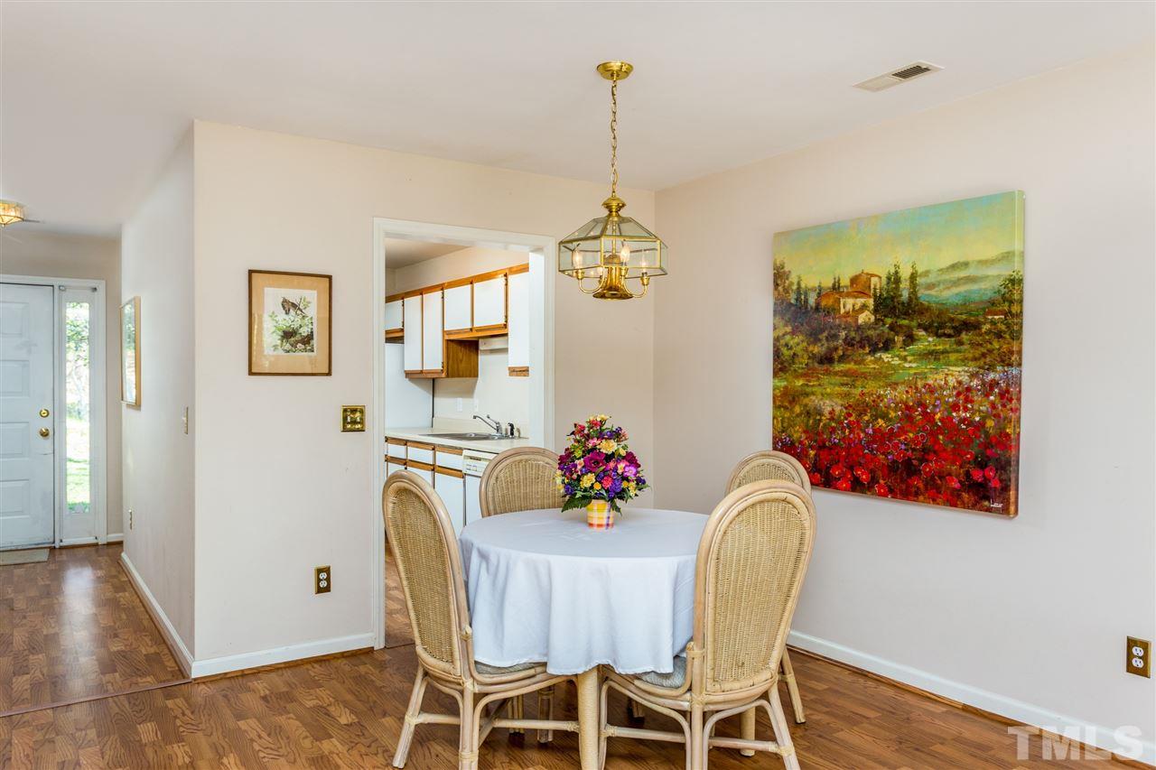 4225 Sunscape Lane Raleigh, NC 27613 - Photo 9 of 23 a view of a dining room with furniture wooden floor and a chandelier