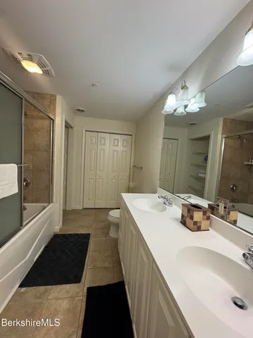 a bathroom with a double vanity sink and a mirror