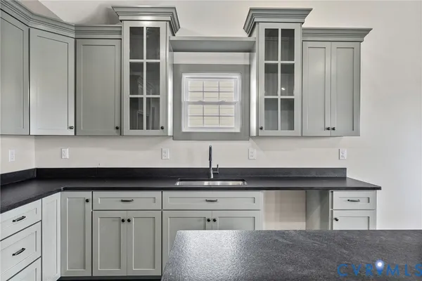 a kitchen with granite countertop a sink stove and cabinets