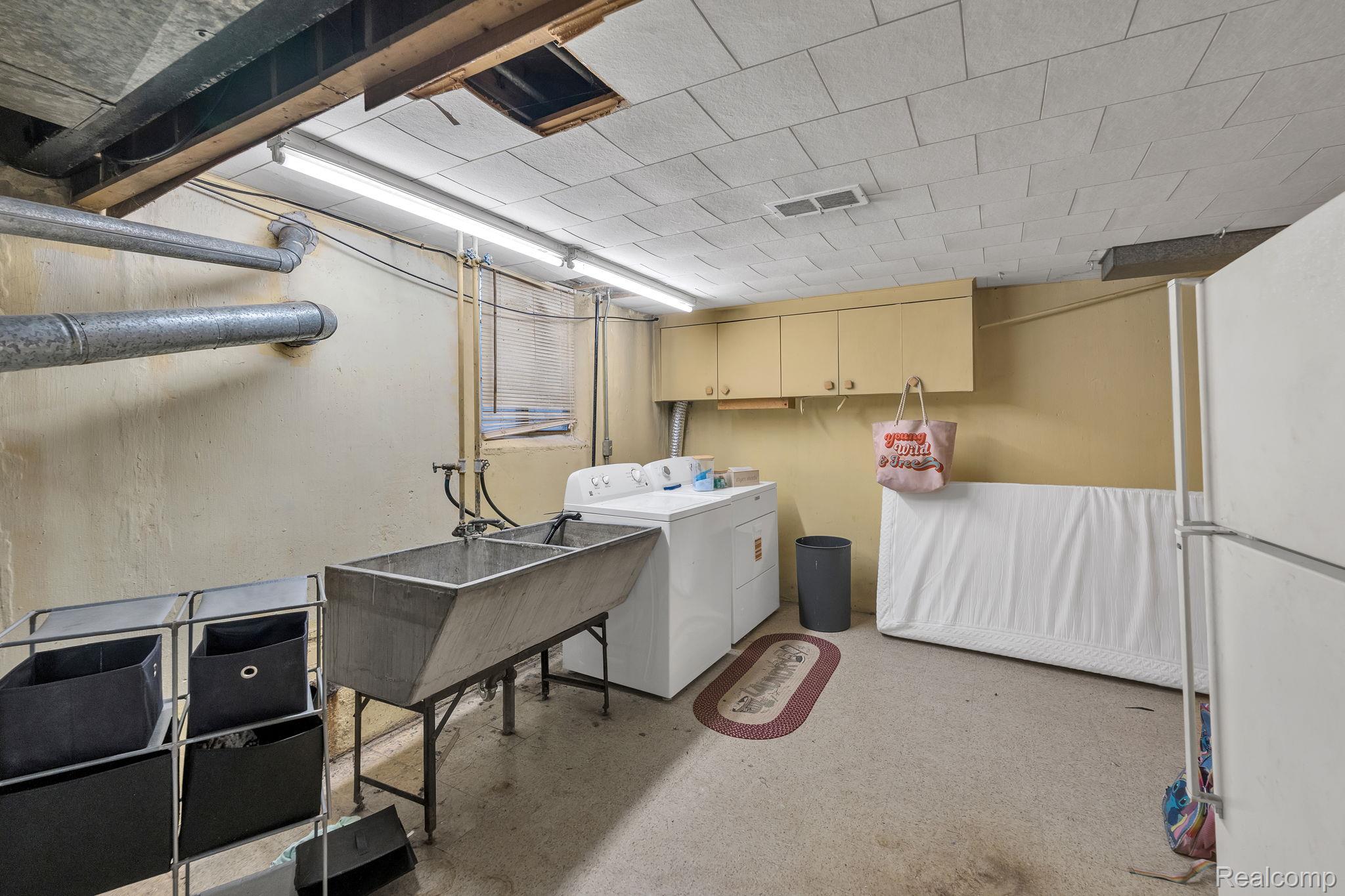 37022 Pinewood Road Wayne, MI 48184 - Photo 20 of 30 Laundry room featuring washer and dryer, concrete flooring, and cabinet space