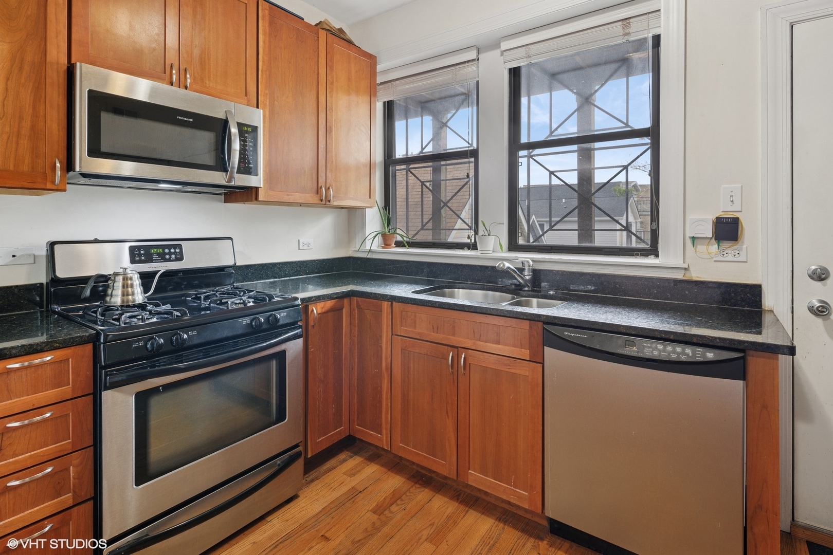 2709 West Altgeld Street, Unit 2 Chicago, IL 60647 - Photo 7 of 13 a kitchen with granite countertop wooden cabinets stainless steel appliances and a sink