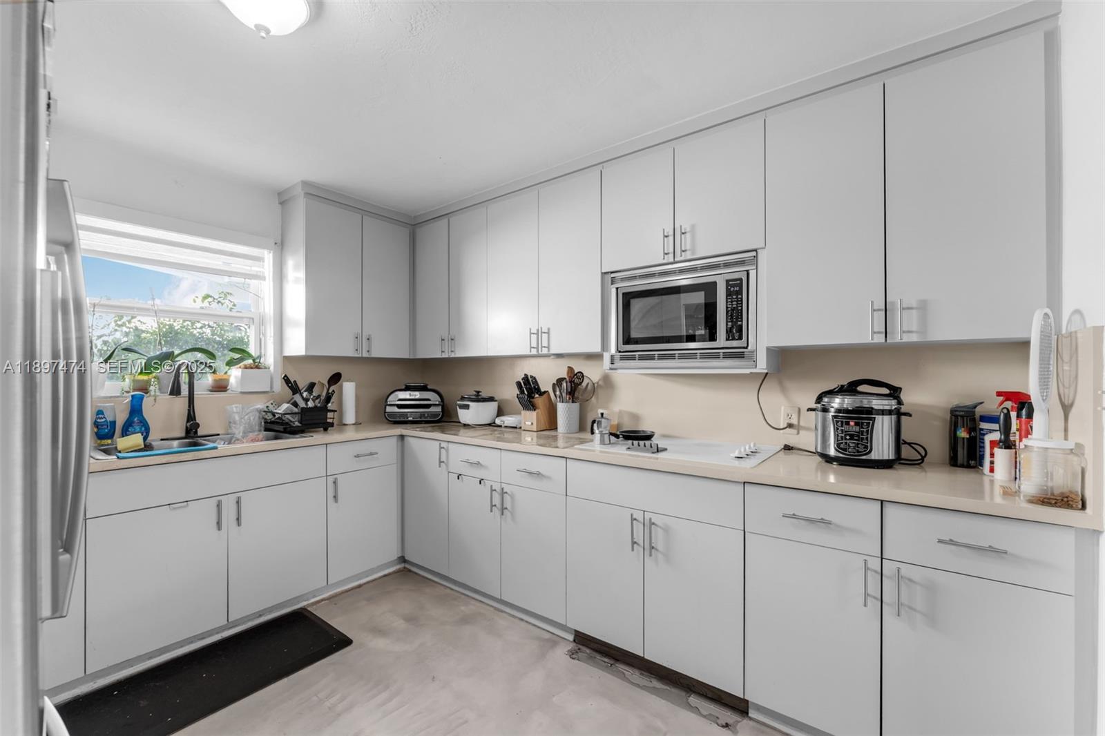 8811 Southwest 128th Street Miami, FL 33176 - Photo 11 of 28 a kitchen with white cabinets sink and window