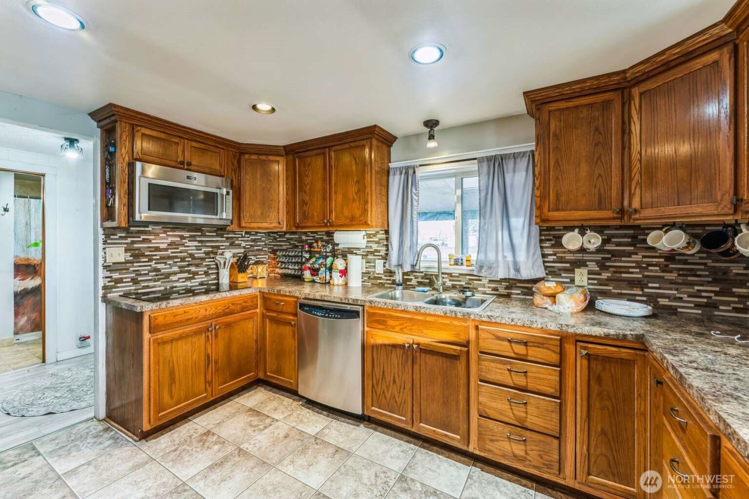 10068 Idano Road Northeast Moses Lake, WA 98837 - Photo 19 of 40 a kitchen with stainless steel appliances granite countertop a sink stove and cabinets