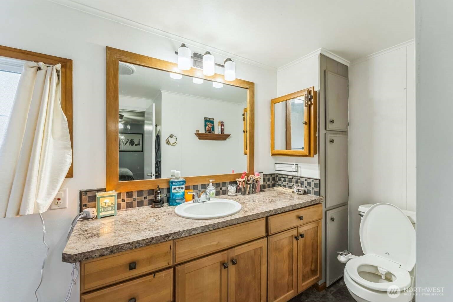 10068 Idano Road Northeast Moses Lake, WA 98837 - Photo 30 of 40 a bathroom with a granite countertop sink toilet and mirror
