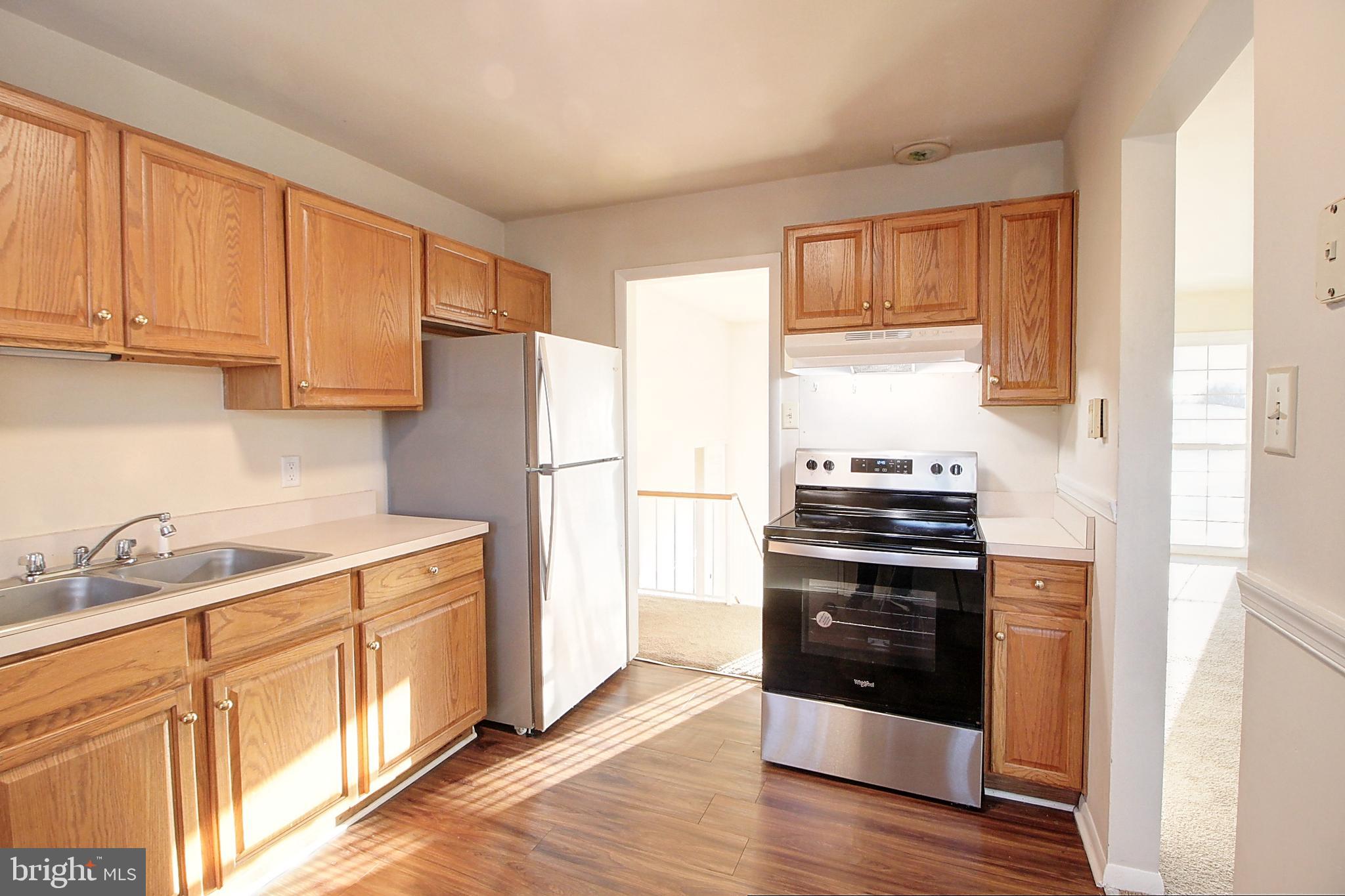 1411 West 12th Street Frederick, MD 21702 - Photo 2 of 16 a kitchen with a refrigerator stove and sink