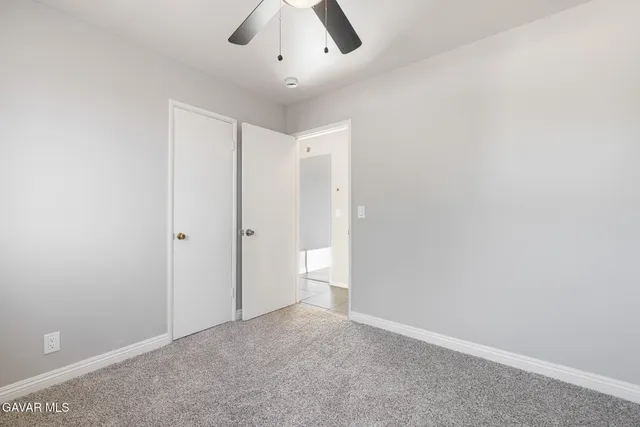 an empty room with a empty space and a ceiling fan