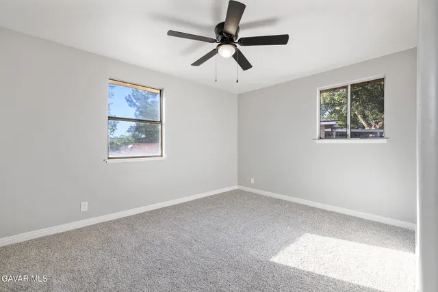 a view of room with ceiling fan and window