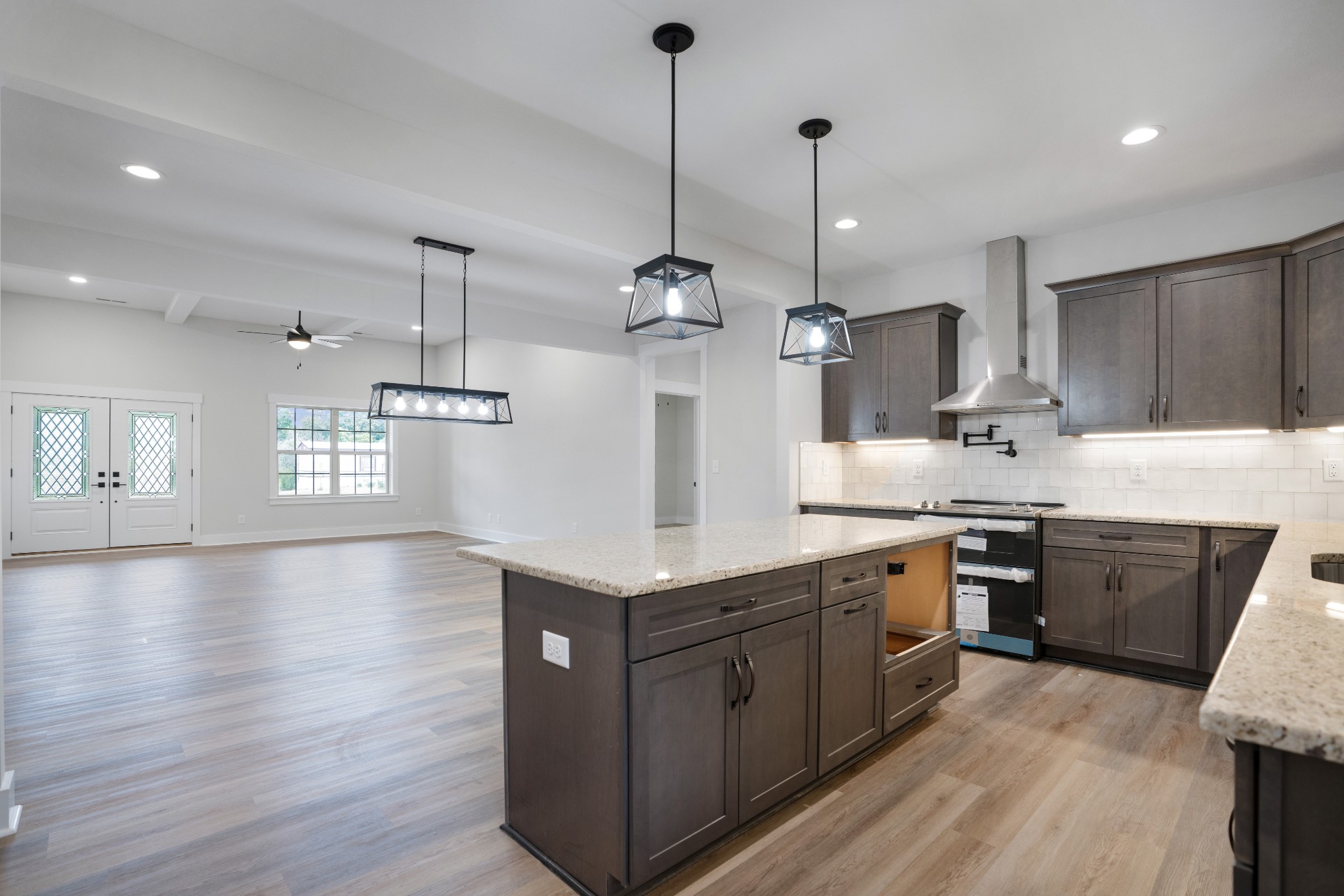 2615 Cooper Creek Road Woodlawn, TN 37191 - Photo 11 of 30 a kitchen with stainless steel appliances kitchen island granite countertop a stove a sink a center island a refrigerator and a wooden floor