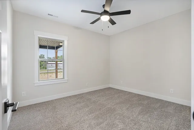 an empty room with a window and a fan