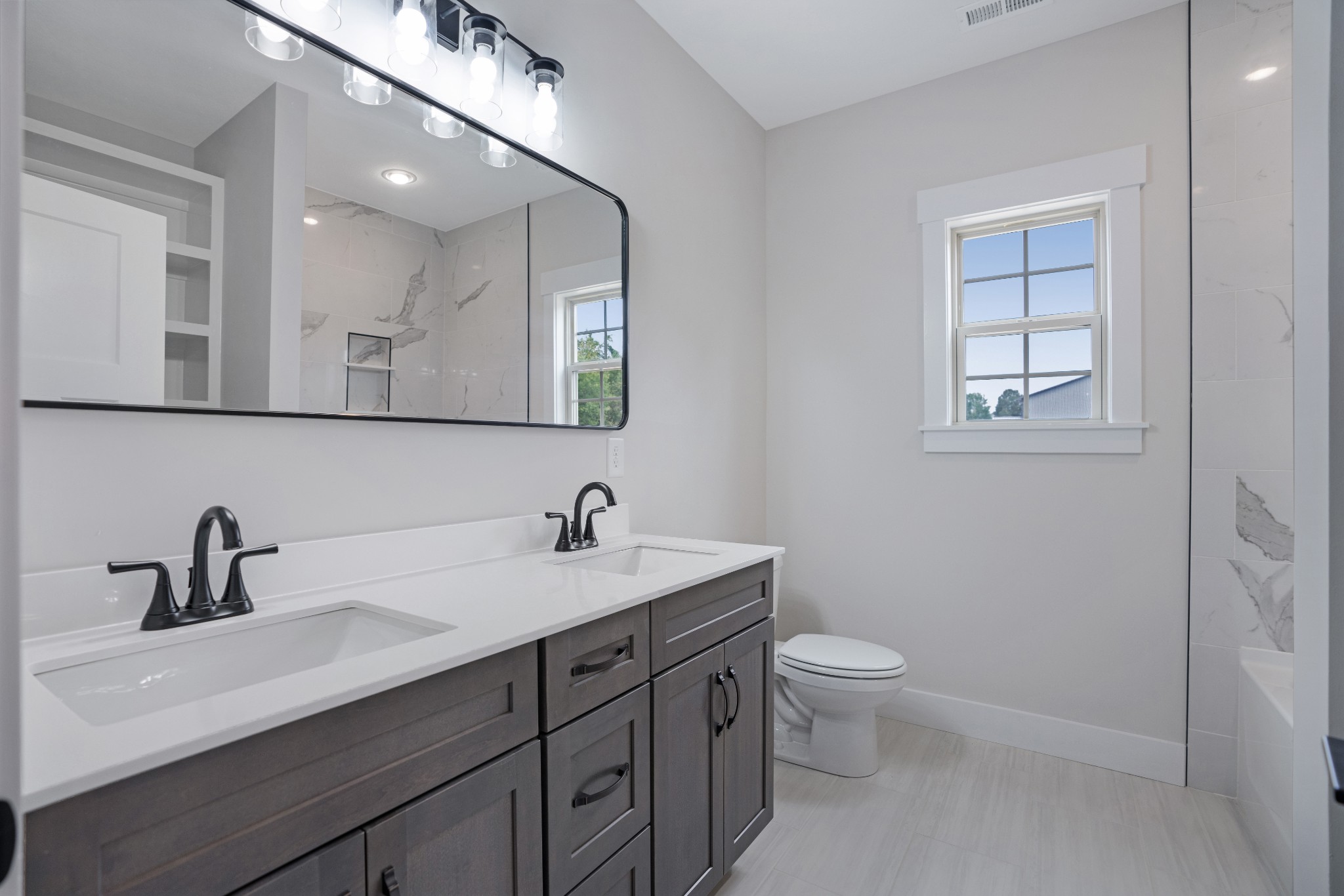 2615 Cooper Creek Road Woodlawn, TN 37191 - Photo 26 of 30 a bathroom with a toilet a sink a mirror and a window
