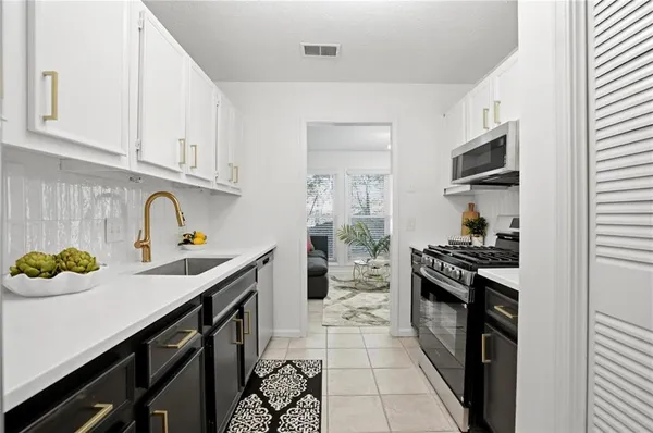 a kitchen with stainless steel appliances a sink stove and cabinets