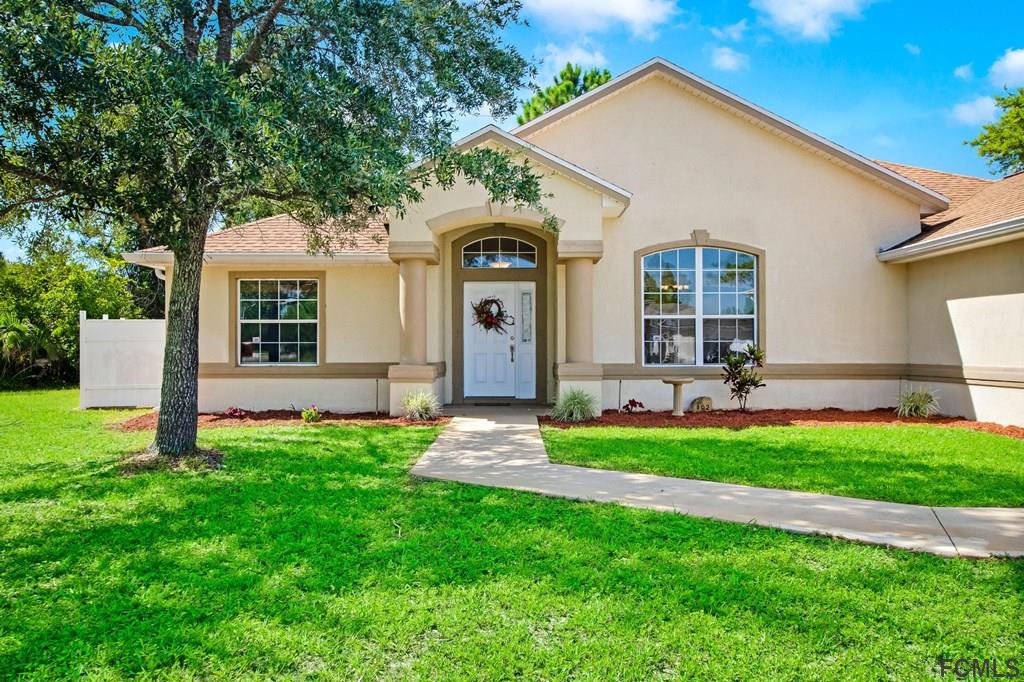 102 Ulysses Trail Palm Coast, FL 32164 - Photo 11 of 62 a front view of a house with a yard and porch