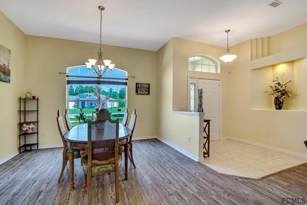 102 Ulysses Trail Palm Coast, FL 32164 - Photo 13 of 62 a view of a dining room with furniture wooden floor and chandelier