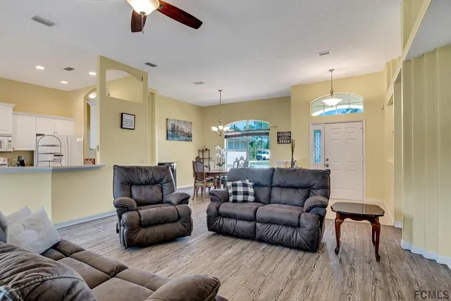 a living room with furniture and a chandelier