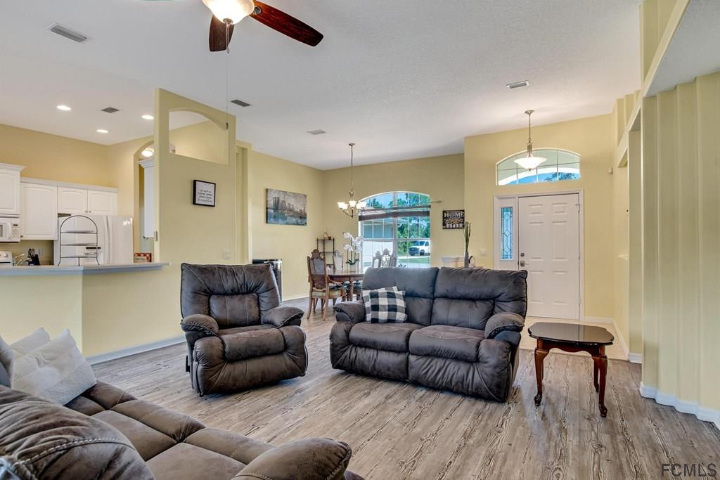 102 Ulysses Trail Palm Coast, FL 32164 - Photo 15 of 62 a living room with furniture and a chandelier