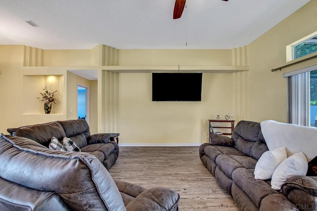 102 Ulysses Trail Palm Coast, FL 32164 - Photo 17 of 62 a living room with furniture and a flat screen tv
