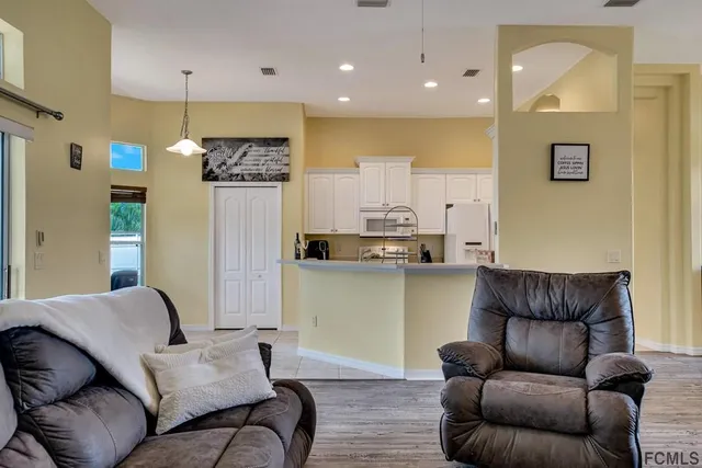 a living room with furniture and kitchen view