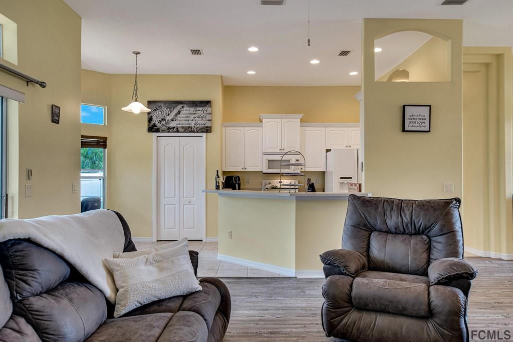 102 Ulysses Trail Palm Coast, FL 32164 - Photo 18 of 62 a living room with furniture and kitchen view