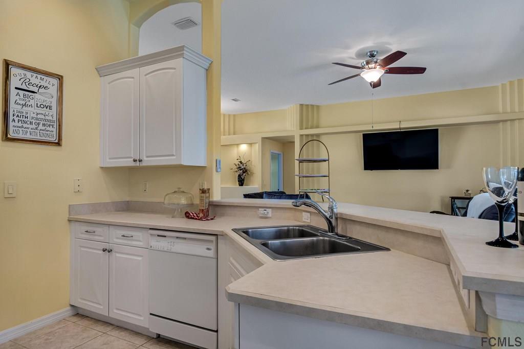 102 Ulysses Trail Palm Coast, FL 32164 - Photo 20 of 62 a kitchen with stainless steel appliances a sink a stove and a microwave