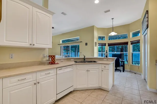 a kitchen with a sink window and cabinets