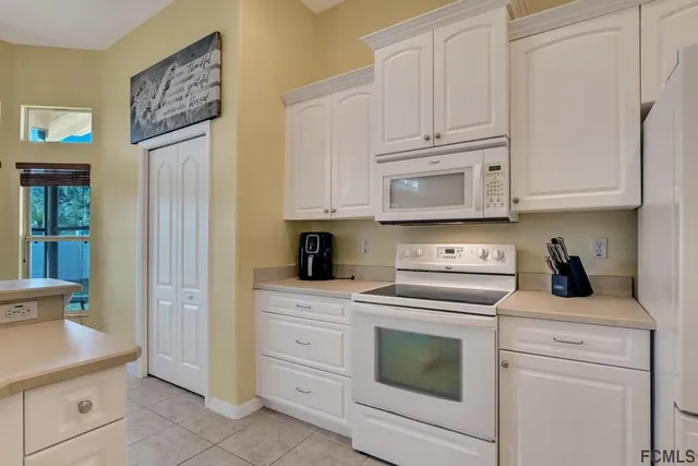 a kitchen with granite countertop white cabinets and stainless steel appliances
