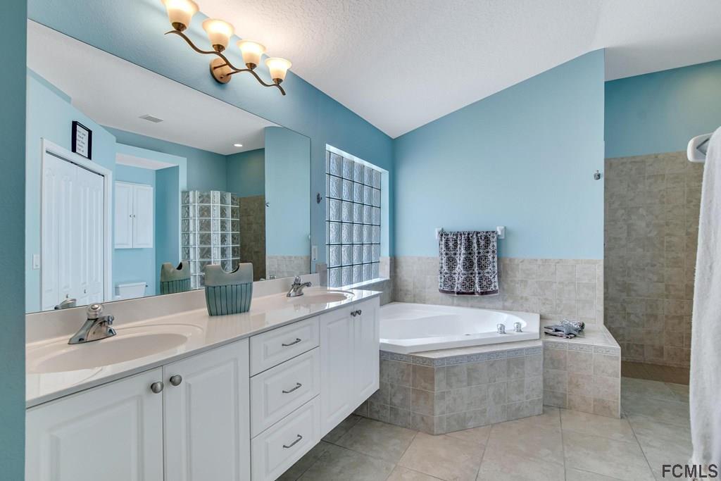 102 Ulysses Trail Palm Coast, FL 32164 - Photo 29 of 62 a bathroom with a double vanity sink mirror and toilet