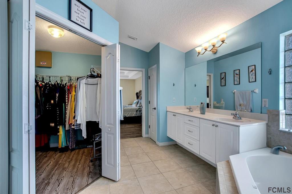 102 Ulysses Trail Palm Coast, FL 32164 - Photo 31 of 62 a large bathroom with a double vanity sink toilet and shower
