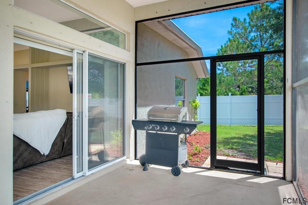 102 Ulysses Trail Palm Coast, FL 32164 - Photo 53 of 62 a view of a porch with furniture and floor to ceiling window