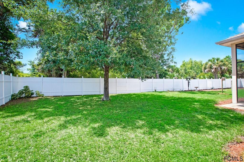 102 Ulysses Trail Palm Coast, FL 32164 - Photo 54 of 62 a view of a yard with a fence and trees