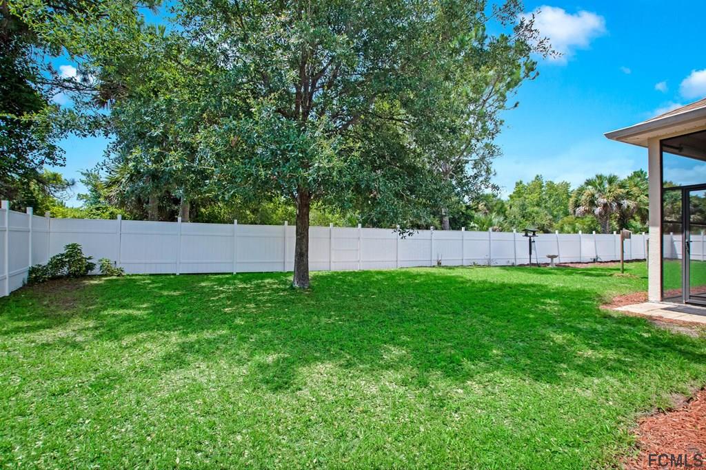 102 Ulysses Trail Palm Coast, FL 32164 - Photo 55 of 62 a view of a yard with a fence and a tree