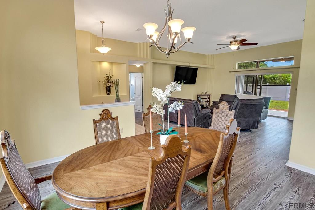 102 Ulysses Trail Palm Coast, FL 32164 - Photo 59 of 62 a view of a dining room with furniture and wooden floor