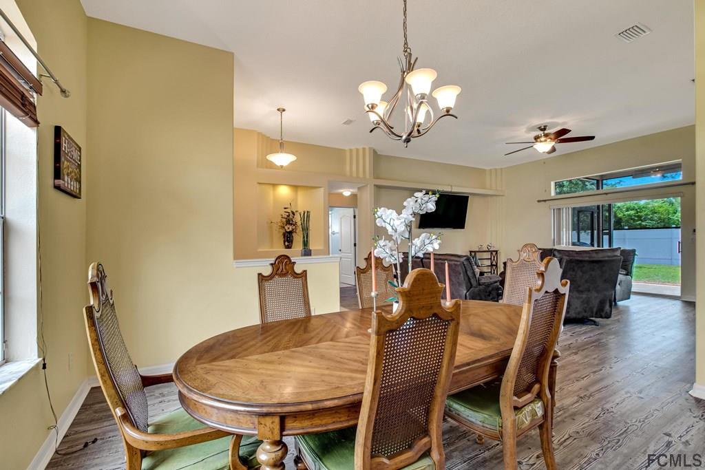 102 Ulysses Trail Palm Coast, FL 32164 - Photo 60 of 62 a view of a dining room with furniture wooden floor and chandelier