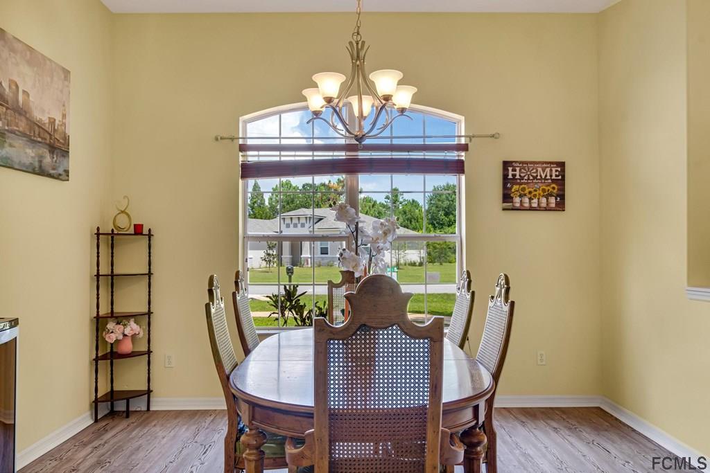 102 Ulysses Trail Palm Coast, FL 32164 - Photo 61 of 62 a view of a dining room with furniture window and wooden floor