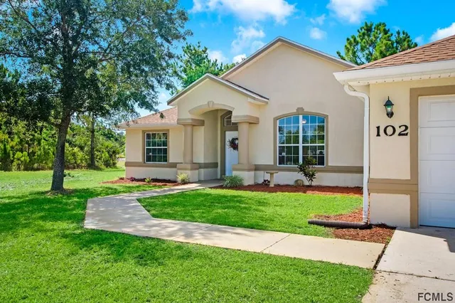 a view of a house with a yard and a garden