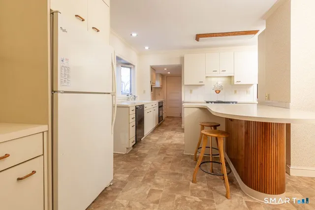 a kitchen with kitchen island a counter top space cabinets and stainless steel appliances
