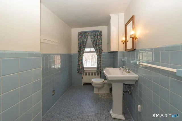 a bathroom with a sink a toilet and window